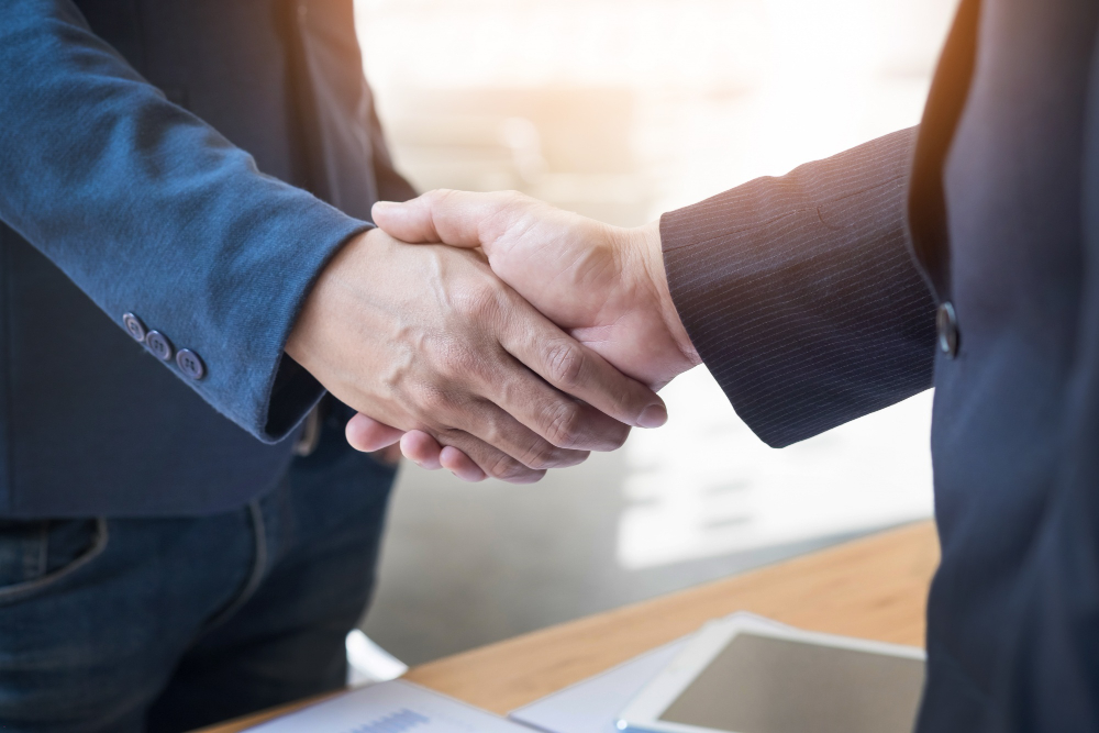 dois-homens-de-negocios-confiantes-apertando-as-maos-durante-uma-reuniao-no-escritorio-sucesso-trato-saudacao-e-conceito-de-parceiro.jpg