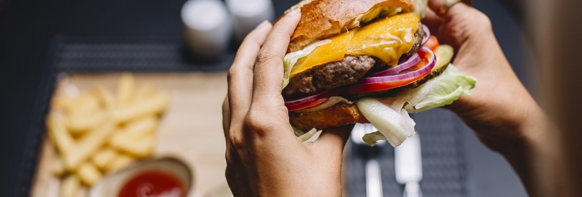 mulher-segura-hamburguer-de-carne-com-alface-tomate-cebola-vermelha-e-queijo-cheddar.jpg